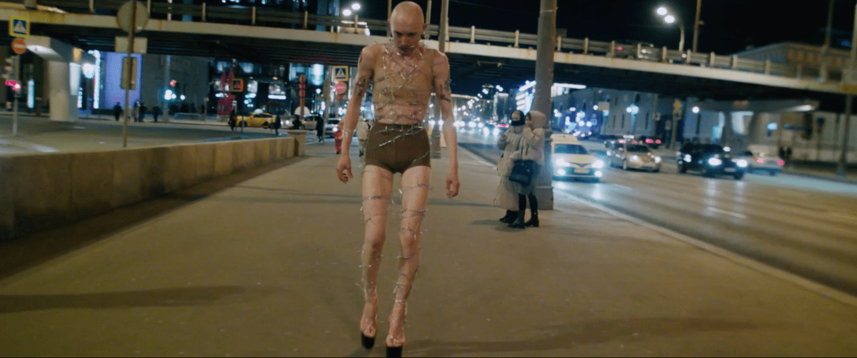 the artist walking in barbed wire
